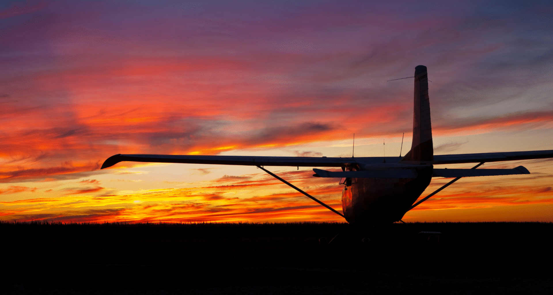 small plane silhouette in front of beautiful sunset