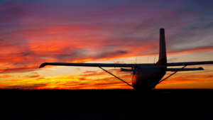 small plane silhouette in front of beautiful sunset