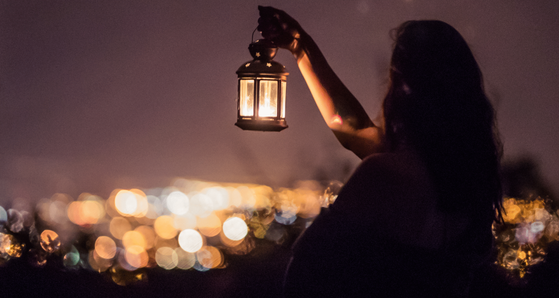 Woman holding lantern in the dark