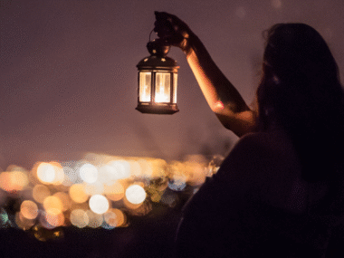 Woman holding lantern in the dark