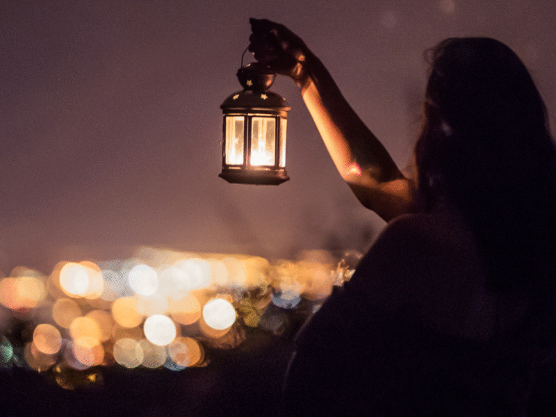 Woman holding lantern in the dark